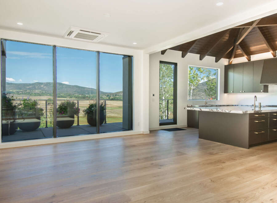 Experience breathtaking mountain views from this stunning modern living space, featuring expansive floor-to-ceiling windows that flood the interior with natural light.