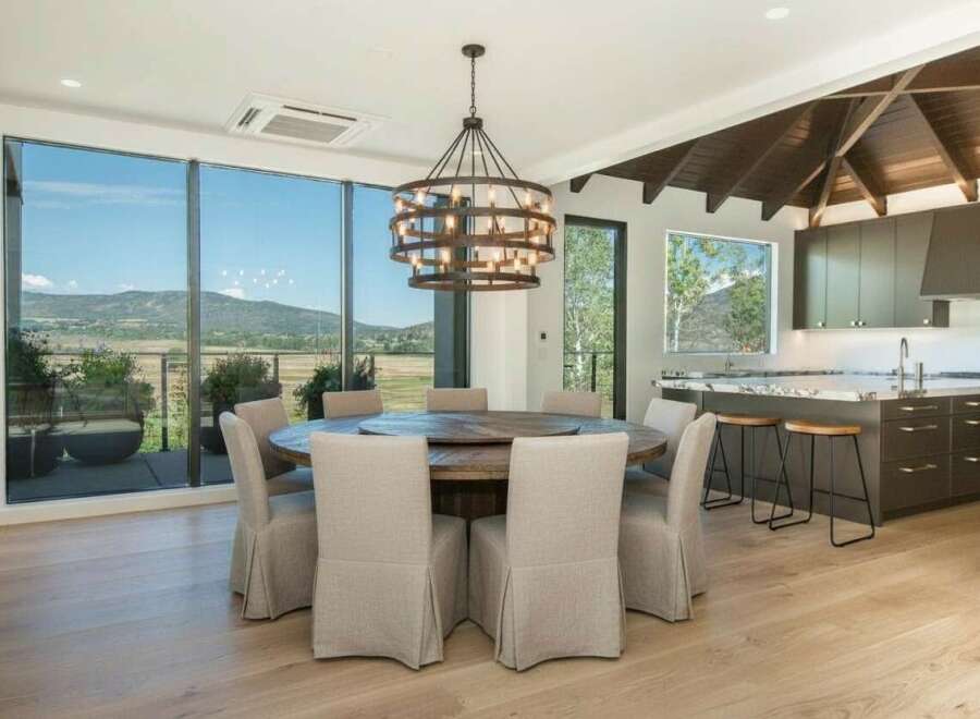 Experience breathtaking mountain views from this stunning dining area, featuring a large round table perfect for gatherings.