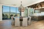 Experience breathtaking mountain views from this stunning dining area, featuring a large round table perfect for gatherings.