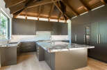 Experience luxury in this modern kitchen featuring sleek, dark cabinetry and stunning marble countertops.