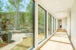 Experience seamless indoor-outdoor living with expansive floor-to-ceiling windows that frame breathtaking views of a lush, natural landscape.