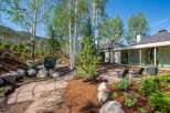 Experience luxury mountain living with this stunning property, featuring a modern home seamlessly integrated into a natural landscape.