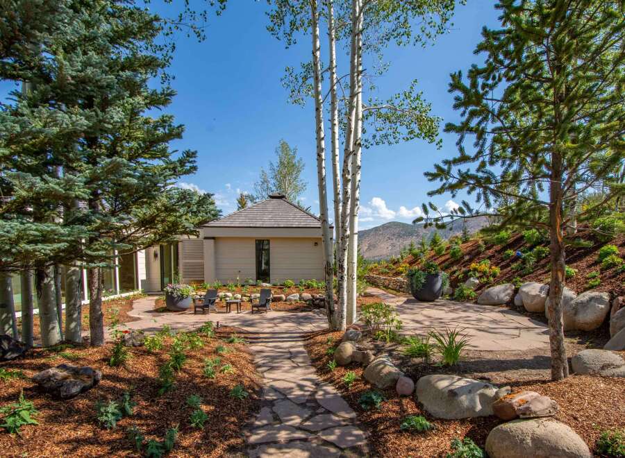 Discover this stunning mountain retreat featuring a modern home with expansive windows and a unique architectural roof.