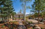 Discover this stunning mountain retreat featuring a modern home with expansive windows and a unique architectural roof.