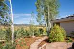 Discover this stunning property featuring a beautifully landscaped yard with a flagstone pathway leading through mature trees and vibrant greenery.