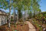 Discover a stunning mountain retreat featuring a beautifully landscaped yard with a flagstone pathway winding through mature aspen trees and vibrant perennial gardens.