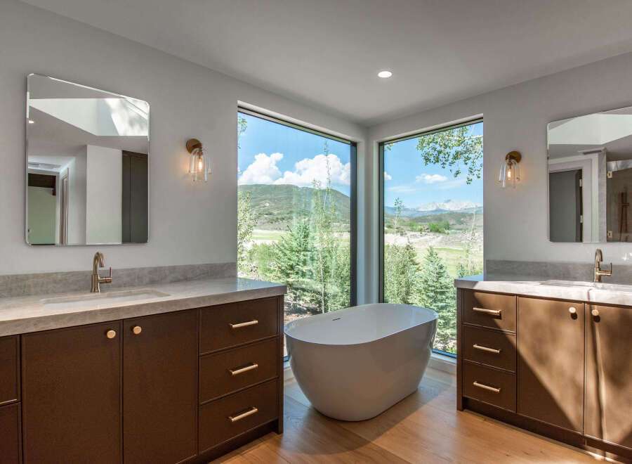 Experience luxury in this stunning bathroom featuring a freestanding bathtub with breathtaking mountain views.