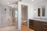 Experience luxury in this modern bathroom featuring a spacious glass-enclosed shower with marble tile and dual showerheads.