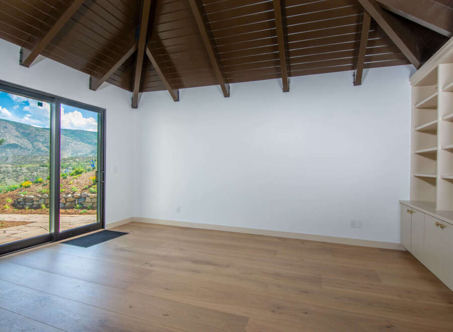 Experience breathtaking mountain views from this spacious room, featuring a modern sliding glass door that opens to a scenic landscape.