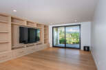 This modern living room features a custom built-in entertainment center with ample shelving and storage, perfect for displaying decor or organizing media.