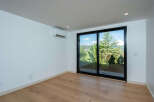 Experience breathtaking mountain views from this spacious room, featuring a large sliding glass door that opens to a lush, green landscape.