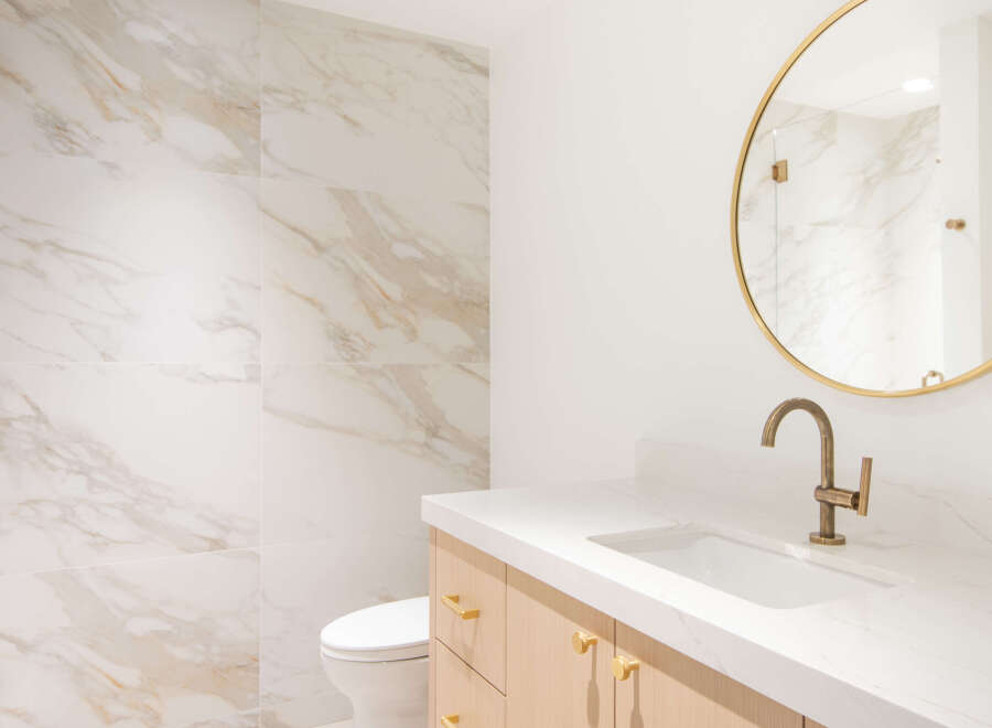 Experience modern luxury in this beautifully appointed bathroom, featuring elegant marble-patterned tiles that create a sophisticated ambiance.