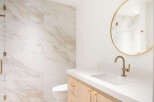 Experience modern luxury in this beautifully appointed bathroom, featuring elegant marble-patterned tiles that create a sophisticated ambiance.