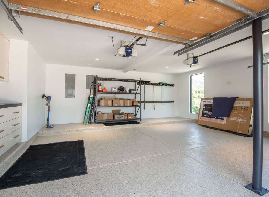 This spacious garage features a durable epoxy-coated floor, perfect for protecting vehicles and providing a clean workspace.