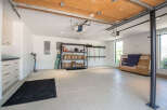 This spacious garage features a durable epoxy-coated floor, perfect for protecting vehicles and providing a clean workspace.
