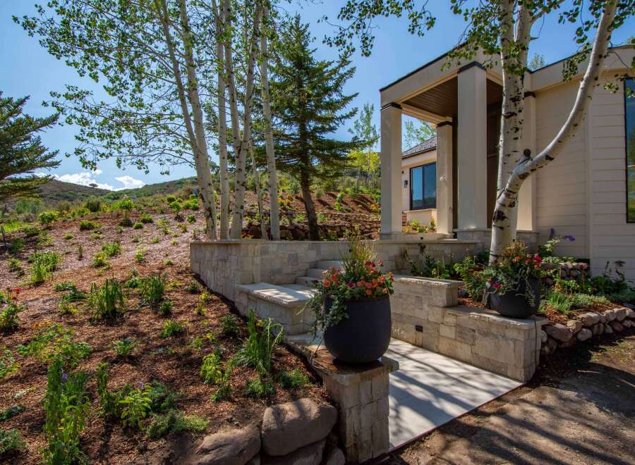 Experience luxury mountain living with this stunning home featuring a modern facade and natural stone accents.