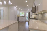 Experience modern luxury in this stunning kitchen, featuring sleek white high-gloss cabinetry and elegant quartz countertops.