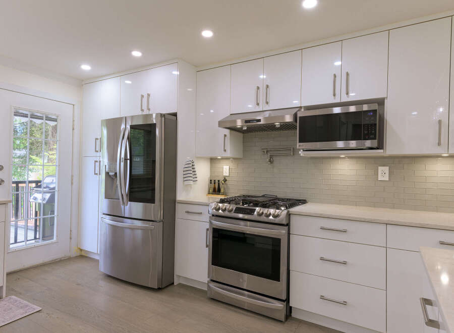 Experience modern living in this stunning kitchen featuring sleek white cabinetry and stainless steel appliances.
