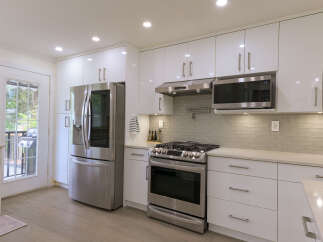 Experience modern living in this stunning kitchen featuring sleek white cabinetry and stainless steel appliances.