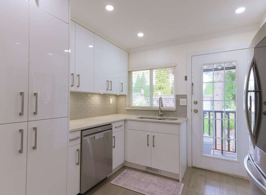 Discover this modern kitchen featuring sleek white cabinetry and a stylish subway tile backsplash.