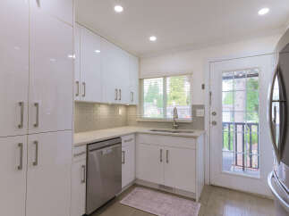 Discover this modern kitchen featuring sleek white cabinetry and a stylish subway tile backsplash.