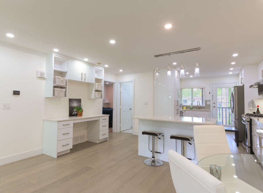 This spacious open-concept living area features a modern kitchen with a large island and sleek white cabinetry, perfect for entertaining.