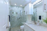 Experience modern luxury in this stunning bathroom, featuring a spacious walk-in shower with elegant marble tile and a built-in bench.