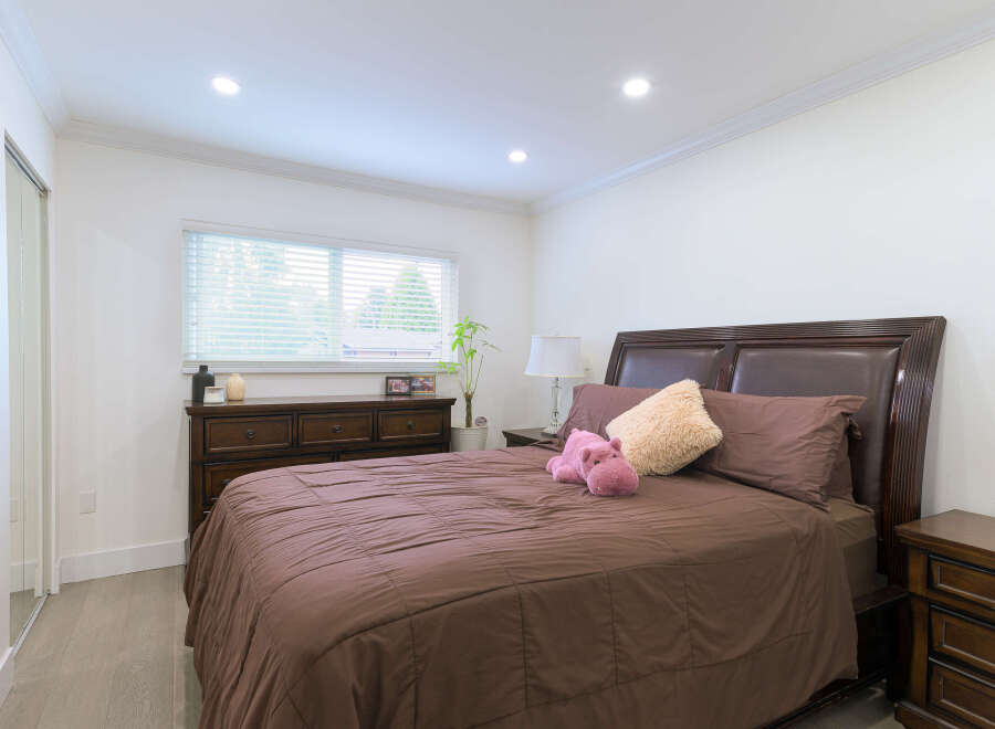 Experience comfort and style in this beautifully appointed bedroom, featuring a plush brown comforter and elegant dark wood furniture.