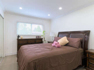 Experience comfort and style in this beautifully appointed bedroom, featuring a plush brown comforter and elegant dark wood furniture.