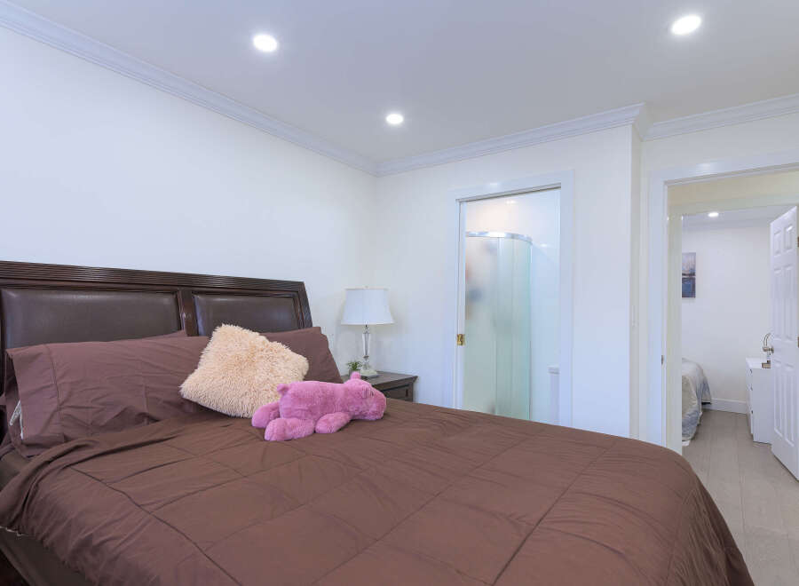 Experience comfort and convenience in this inviting bedroom, featuring a plush brown comforter and a stylish dark wood headboard.