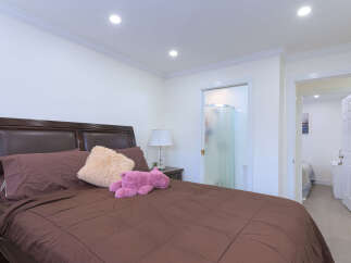 Experience comfort and convenience in this inviting bedroom, featuring a plush brown comforter and a stylish dark wood headboard.