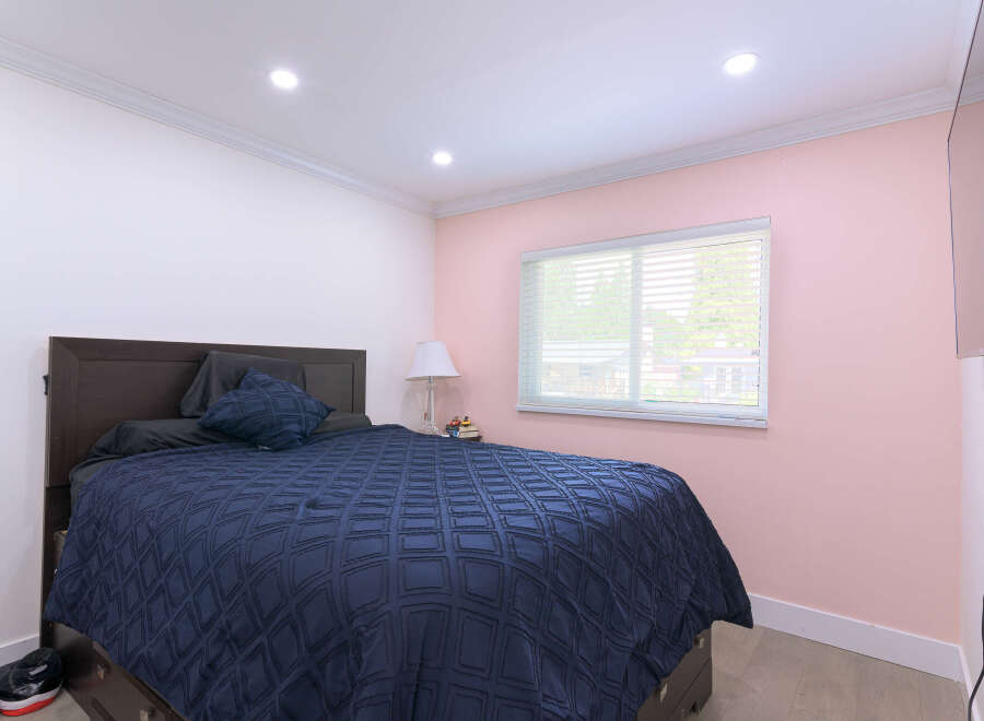 Experience comfort and style in this inviting bedroom, featuring a plush navy blue comforter on a dark wood bed frame.