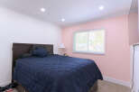 Experience comfort and style in this inviting bedroom, featuring a plush navy blue comforter on a dark wood bed frame.