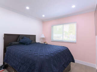 Experience comfort and style in this inviting bedroom, featuring a plush navy blue comforter on a dark wood bed frame.