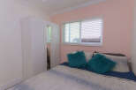 Discover this charming bedroom featuring a spacious white wardrobe with mirrored doors, perfect for ample storage.