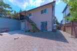 Enjoy outdoor living in this spacious backyard featuring a paved patio perfect for entertaining and a raised deck with seating.