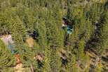 Nestled within a dense forest of tall pine trees, this property offers a secluded mountain retreat.