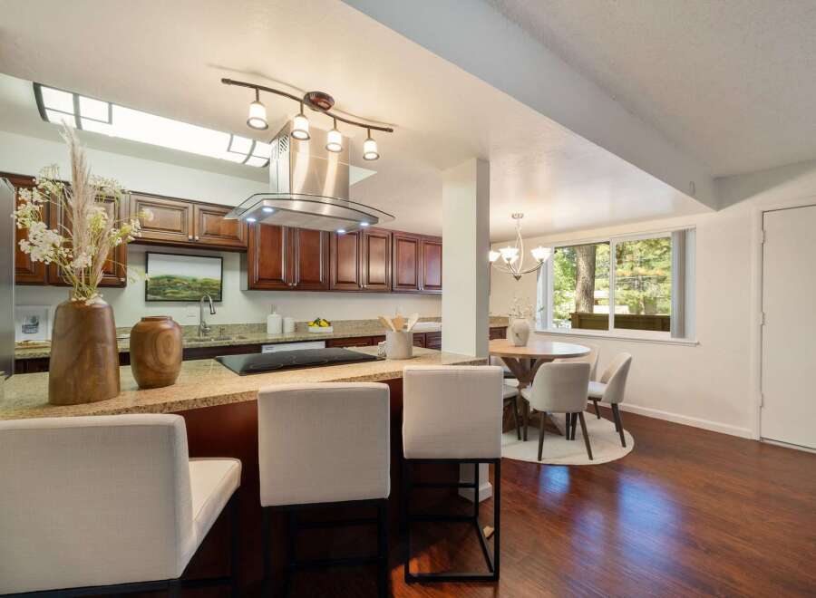 This spacious kitchen features rich cherry wood cabinets and a granite countertop island, perfect for casual dining or entertaining.