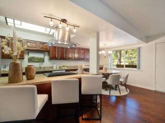 This spacious kitchen features rich cherry wood cabinets and a granite countertop island, perfect for casual dining or entertaining.
