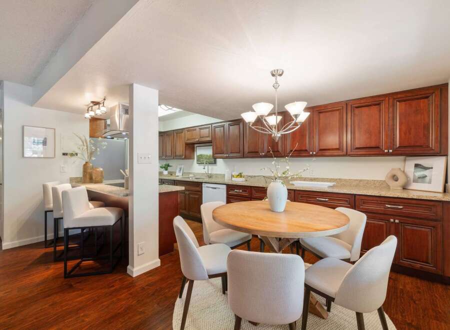 This inviting kitchen features rich cherry wood cabinetry complemented by granite countertops, offering ample storage and a sophisticated aesthetic.