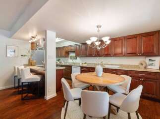This inviting kitchen features rich cherry wood cabinetry complemented by granite countertops, offering ample storage and a sophisticated aesthetic.