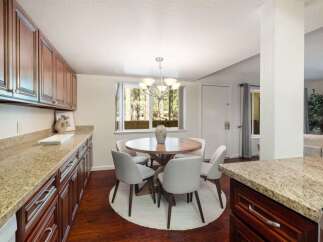 Enjoy meals in this charming dining area, featuring a round wooden table with four upholstered chairs, perfect for intimate gatherings.