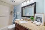 This charming bathroom features a spacious vanity with a granite countertop and dark wood cabinetry, offering ample storage.