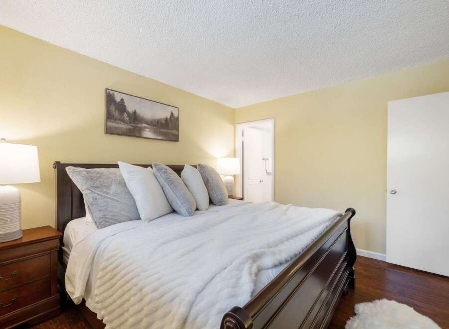 Experience ultimate comfort in this beautifully appointed bedroom, featuring a plush king-size bed adorned with soft, inviting pillows and a luxurious white duvet.