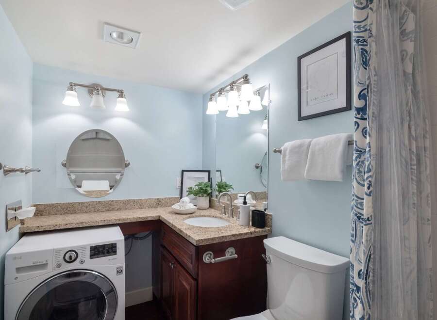 This bright and airy bathroom features a convenient in-unit washer and dryer, perfect for modern living.
