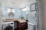 This bright and airy bathroom features a convenient in-unit washer and dryer, perfect for modern living.