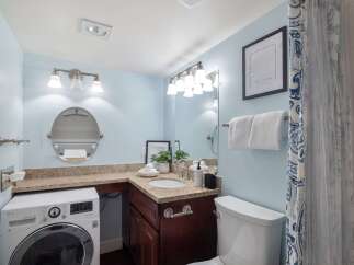 This bright and airy bathroom features a convenient in-unit washer and dryer, perfect for modern living.