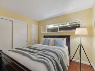 This cozy bedroom features a comfortable queen-size bed with plush bedding and decorative pillows, perfect for a restful night's sleep.