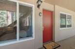 Welcome guests to this charming property with a vibrant red door and a welcoming 'hello' doormat.