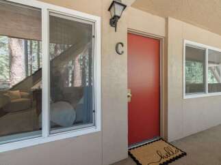 Welcome guests to this charming property with a vibrant red door and a welcoming 'hello' doormat.